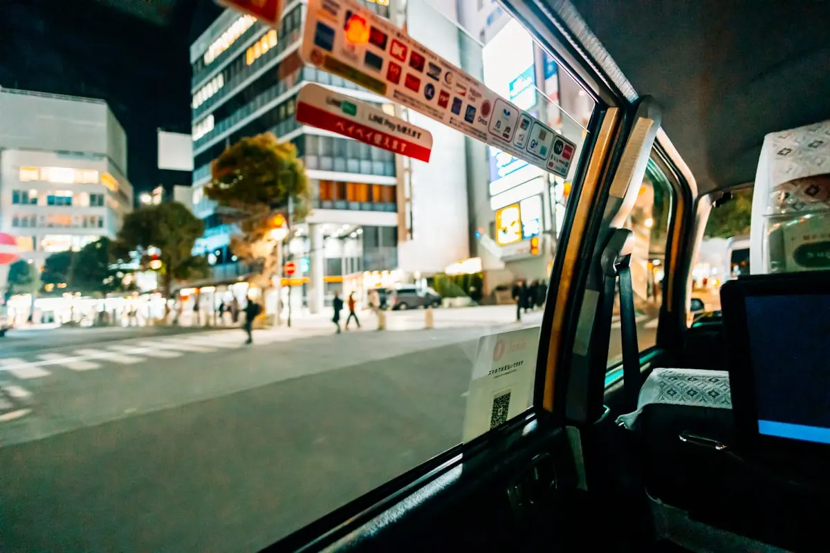 밤 도쿄 도로를 달리는 차량 안에서 보이는 택시와 거리 불빛