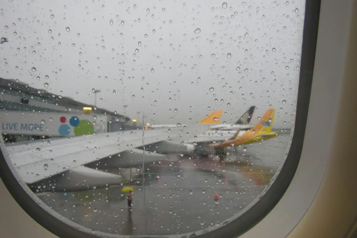 비 오는 마닐라공항 계류장에 항공기가 보이는 장면