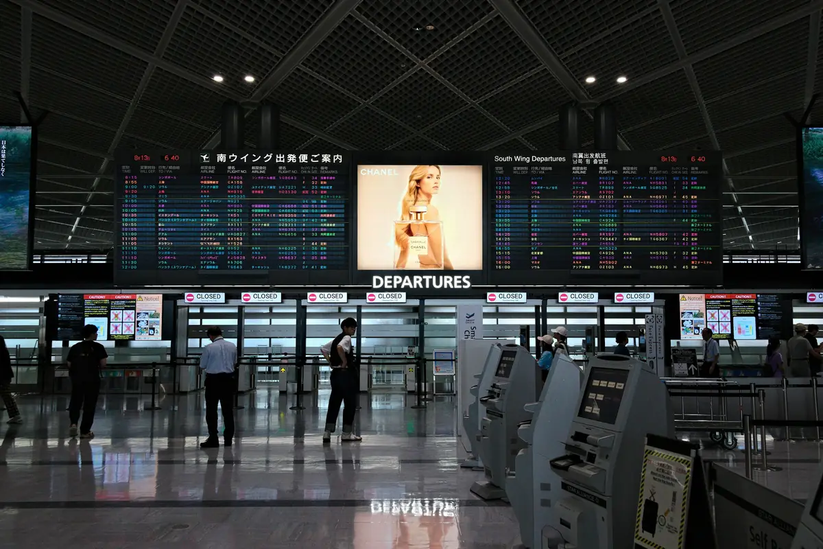 나리타공항 터미널의 전광판과 셀프 체크인 구역